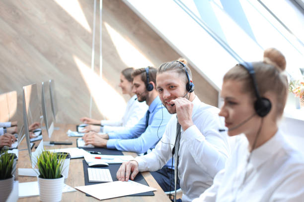 istock Portrait of call center worker accompanied by his team. Smiling customer support operator at work. 1181989242