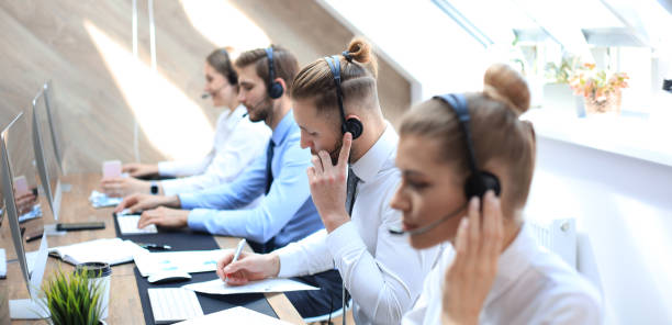 istock Portrait of call center worker accompanied by his team. Smiling customer support operator at work. 1181989278