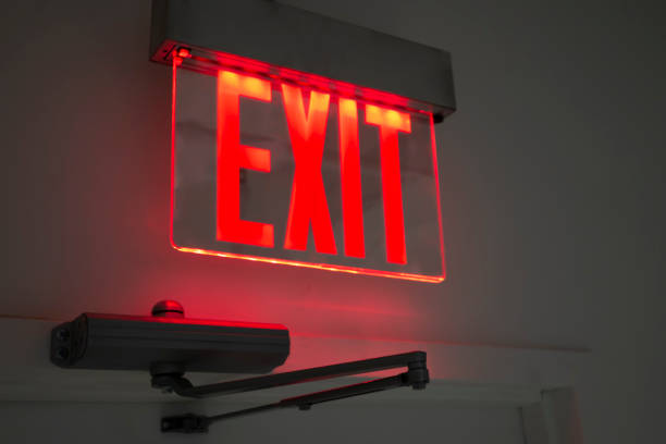istock plexiglas red and yellow lighted exit sign over office doorway 1181989309