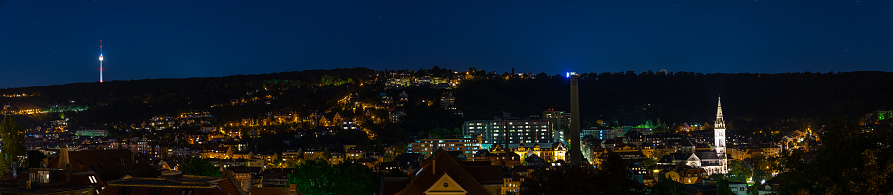 Germany, XXL panorama of of stuttgart heslach houses, television tower and illuminated church of matthew by night under starry sky, scenic view from above
