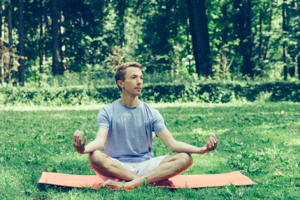 istock Young attractive man in sport clothes is meditating 1181992104
