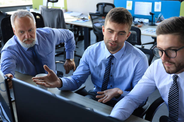 istock Group of young business men in formalwear working using computers while sitting in the office. 1181993570
