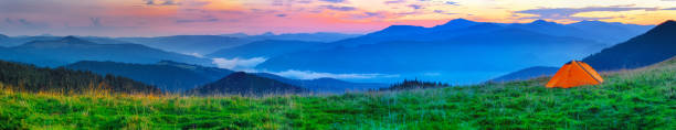 istock Orange tent on plain in the mountains 1181994715