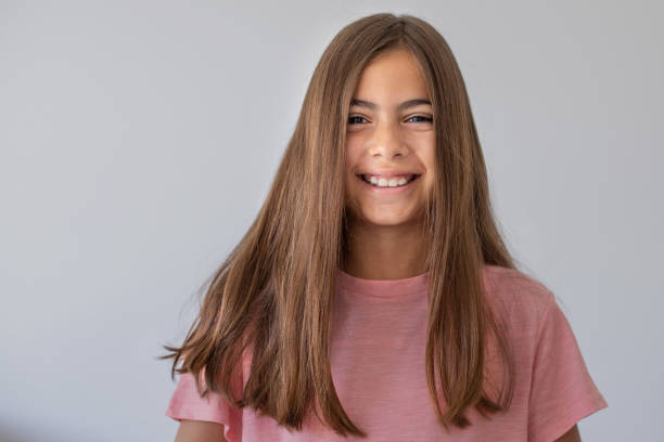 портрет 9-летней девочки с длинными волосами. она смотрит в камеру - female 8 9 years child excitement стоковые фото и изображения