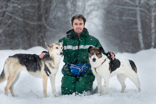 istock Two dogs walk outdoors in winter with an owner 1182003679