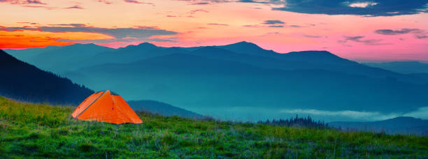 istock Orange tent in mountains at sunset 1182010116