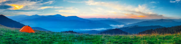 istock Orange tent on a plain in the mountains 1182010194