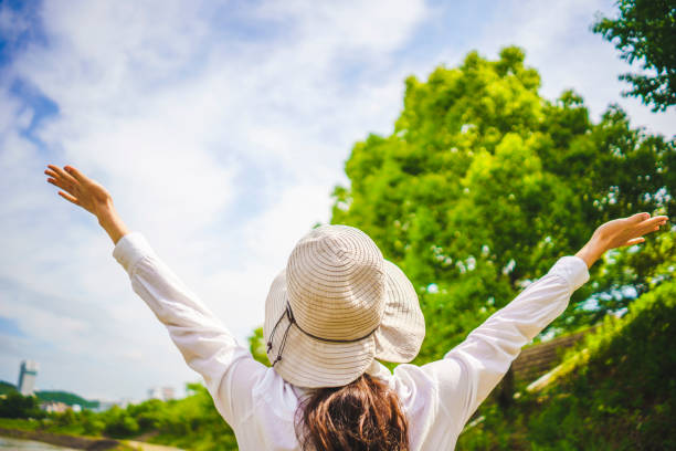istock Woman in hat walking in fresh green 1182010853