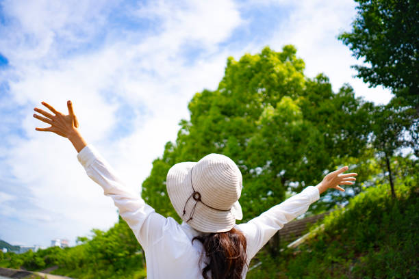istock Woman in hat walking in fresh green 1182010873