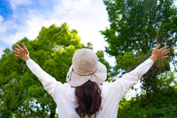 istock Woman in hat walking in fresh green 1182010913