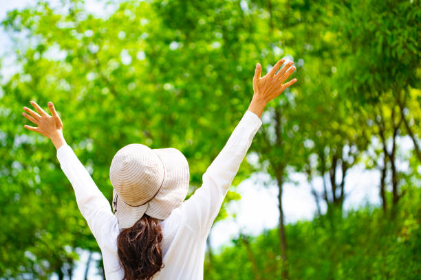 istock Woman in hat walking in fresh green 1182010927