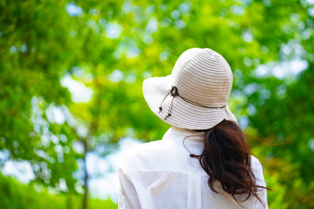istock Woman in hat walking in fresh green 1182010980