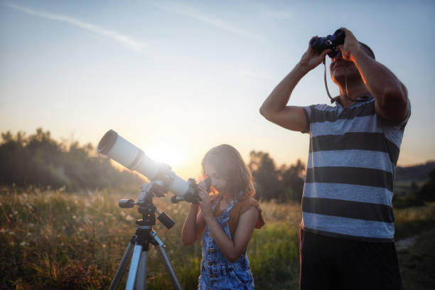 istock Father and daughter observing the sky with a telescope. 1182011443