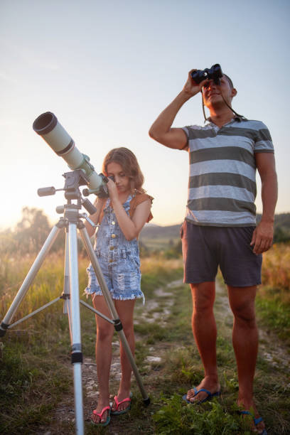 istock Father and daughter observing the sky with a telescope. 1182011472