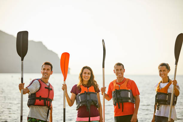 istock Smiling friends with oars at riverbank 1182012103