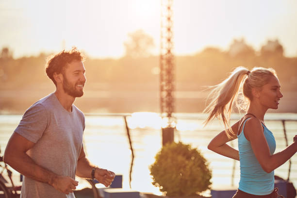 istock Modern woman and man jogging / exercising in urban surroundings near the river. 1182013473