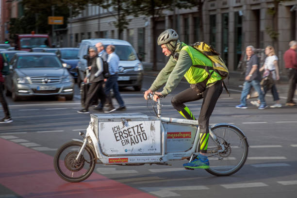 Young man on a cargo bike Berlin, Germany, September 23, 2019: Young man on a cargo bike wich is a popular alternative to small box cars in the center of Berlin cargo bike photos stock pictures, royalty-free photos & images