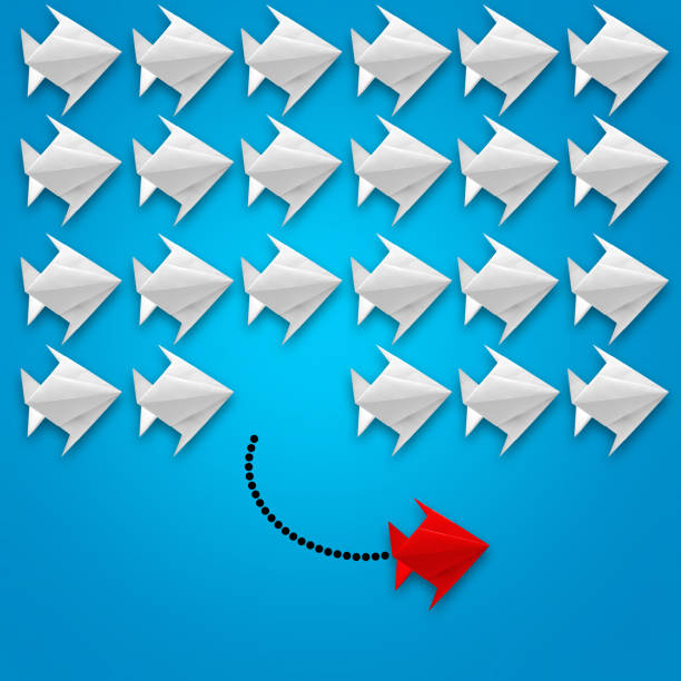istock Flying paper fish origami with a red one on blue background. 1182015109