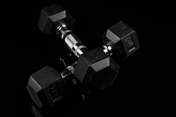 istock sports dumbbells with black rubber handle on black isolated background 1182015756