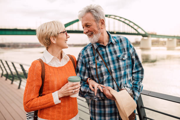 istock Happy seniors walking by the river 1182016023