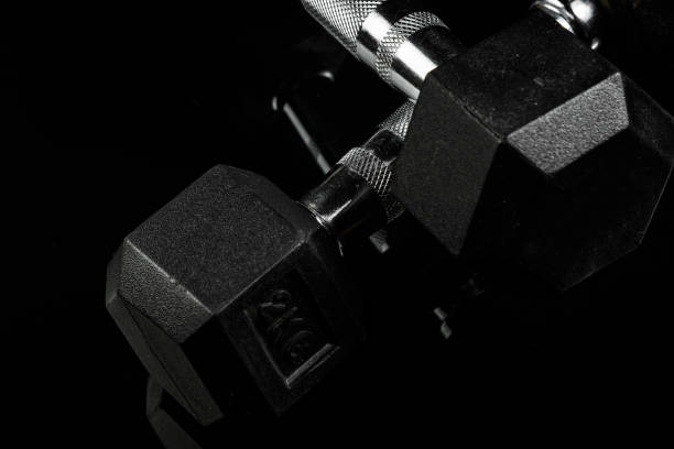 istock sports dumbbells with black rubber handle on black isolated background 1182016083