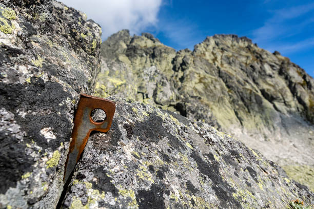 istock Angle piton embedded in the rock in the background a mountain ridge. A piton made of steel sheet bent into V shape. Work well for larger cracks. 1182019668
