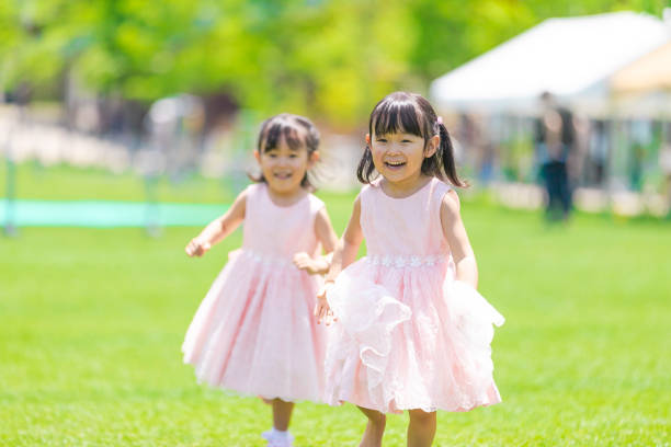 istock Twin girls running on the grass 1182023249