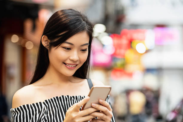 istock Attractive Asian woman texting on phone 1182027732