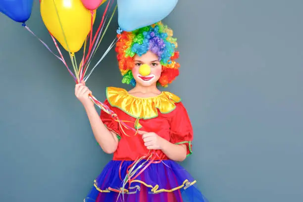 Photo of Girl clown holding lots of balloons getting ready for carnival