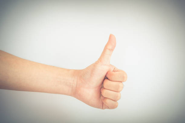 istock Filtered image studio shot full arm Asian man hand with thumbs up isolated on white 1182030189