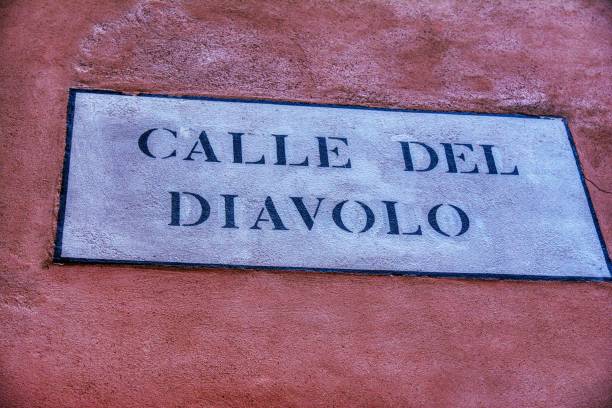 istock Road sign with text Calle del Diavolo 1182030205