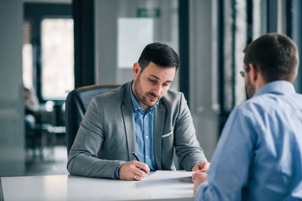 Businessman holding a document and pen, has questions to agreement conditions, unsure about signing the contract. Businessman holding a document and pen, has questions to agreement conditions, unsure about signing the contract. cancelled stock pictures, royalty-free photos & images