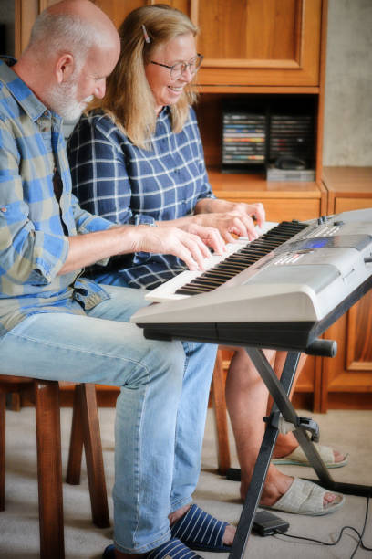 istock attractive couple playing piano at home 1182032509