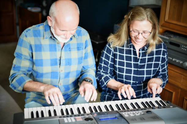 istock attractive couple playing piano at home 1182033271