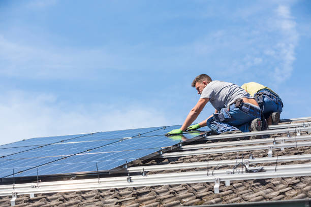 istock Low Angle View Of Workers Installing Solar Panels On Roof Against Sky 1182042584