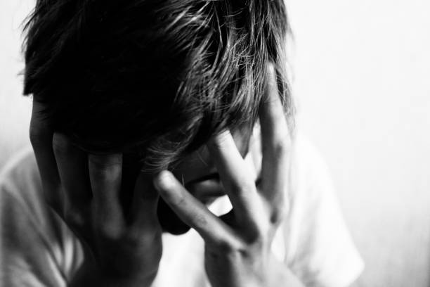 istock 18 year old guy squeezes his head with his hands 1182045004