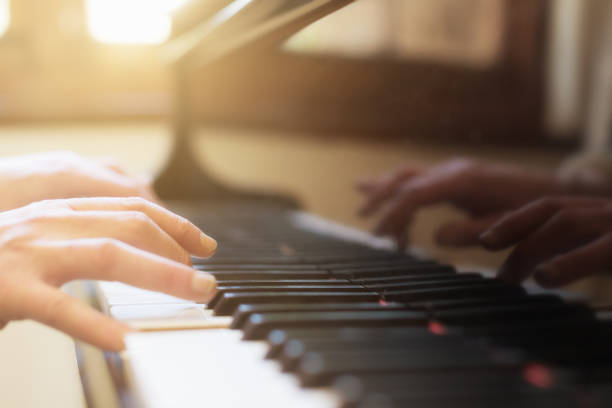 istock Musician's hands playing a magnficent grand piano keyboard 1182047632