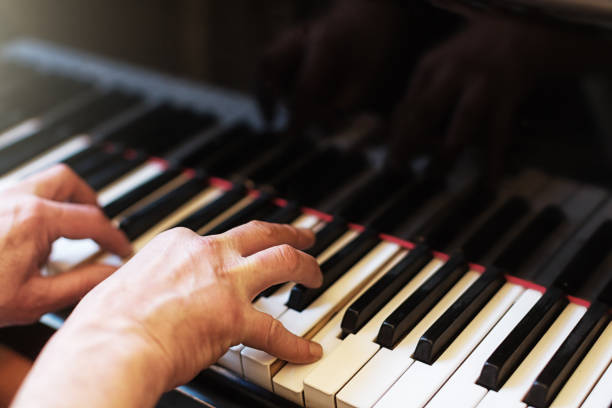 istock Musician's hands playing a magnficent grand piano keyboard 1182048162