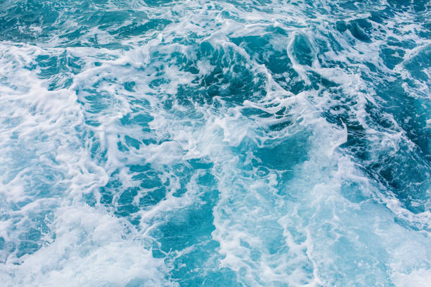 istock Turquoise sea surface background with splashing waves 1182050909