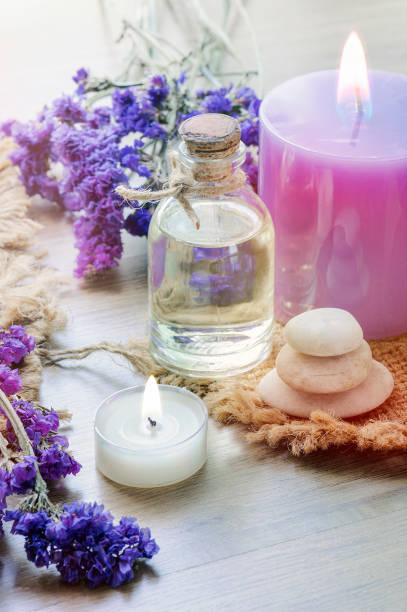 istock Bottle with lavender essential oil , candle on wooden table. Vertical view. 1182053408