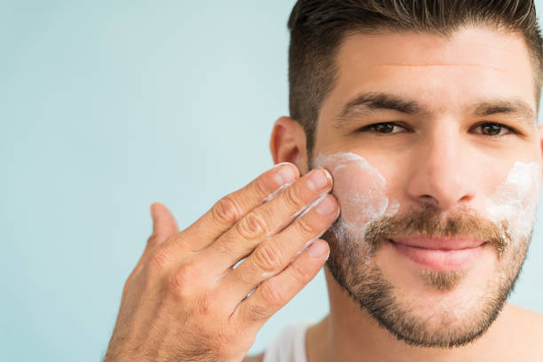 istock Handsome Latin Man Applying Moisturizer On Face 1182053973
