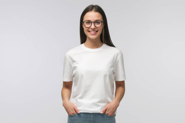 Young Smiling Woman Standing With Hands In Pockets Wearing Blank White Tshirt With Copy Space Isolated On Gray Background Stock Photo - Download Image Now - iStock Young Smiling Woman Standing With Hands In Pockets Wearing Blank White Tshirt With Copy Space Isolated On Gray Background Stock Photo - Download Image Now - Istock
