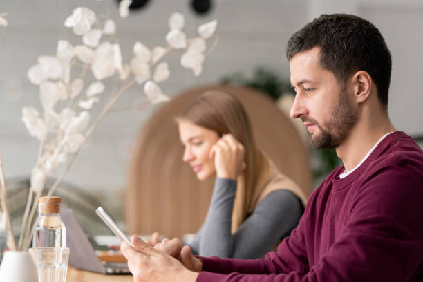 istock Serious man in casualwear scrolling in touchpad while sitting in cafe 1182060000