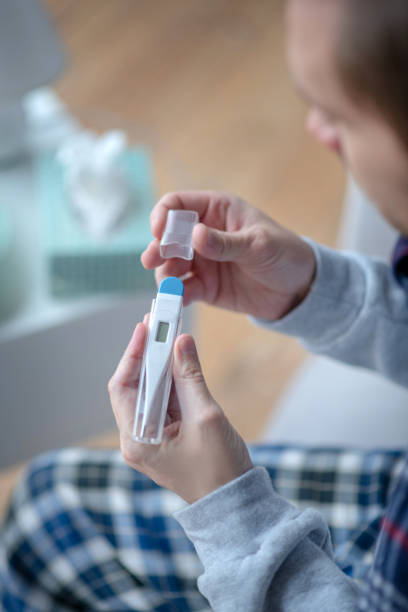 istock Top view of man holding thermometer while having flu 1182062531