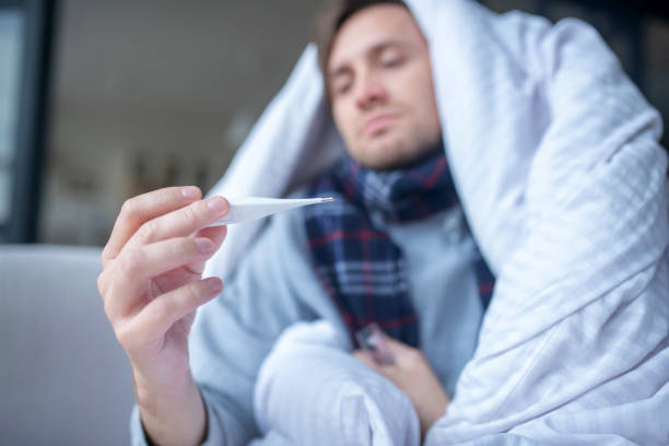 istock Close up of man feeling cold measuring body temperature 1182062868