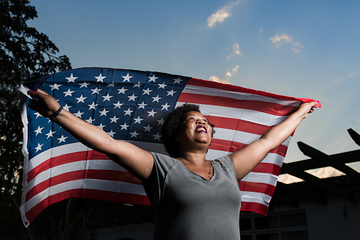 Proud woman raising the flag of the United States of America