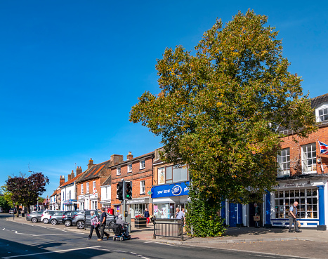 People crossing the road on a pedestrian crossing in Swaffham, Norfolk, Eastern England, on a sunny day in September. Swaffham is a typically English market town.