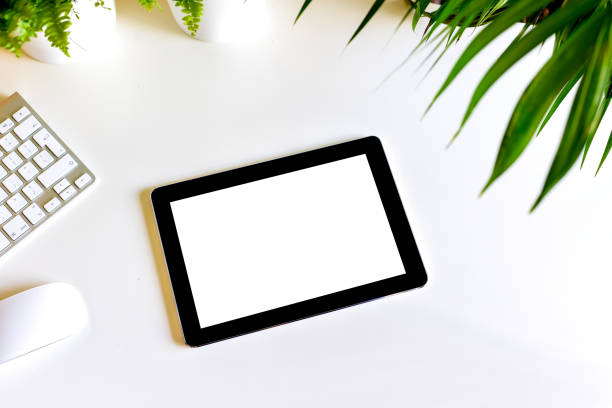 istock Blank white screen on portable tablet device on modern office desk 1182065877