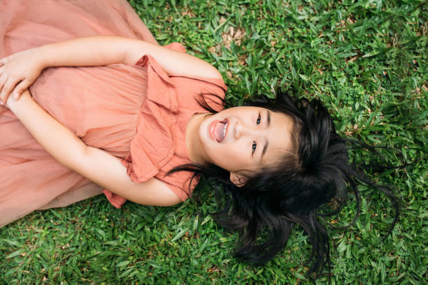 istock Happy Asian Girl lie down on grass 1182065994