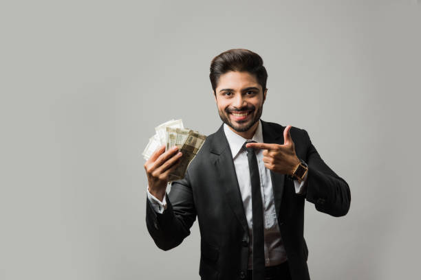 счастливый бородатый индийский бизнесмен, держащий вентилятор в руке, индийские купюры рупии валюты 500 , стоя изолированные на белом фоне - greed currency men happiness стоковые фото и изображения